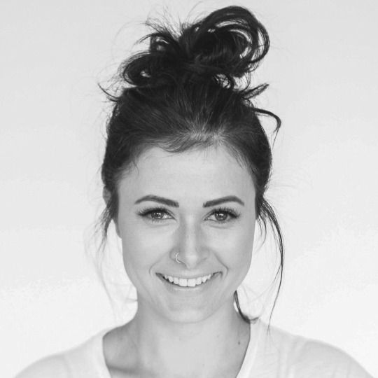 Black-and-white portrait of smiling woman with messy bun